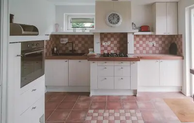 a kitchen with white cabinets and a tile floor at Pet Friendly Home In Zeewolde With Wifi in Zeewolde