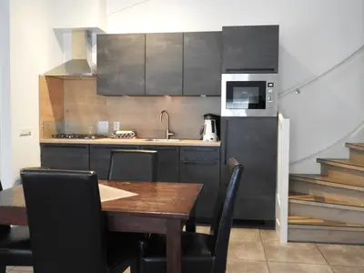 a kitchen with a table and a sink and a refrigerator at Apartement De Vosseburch in Langeraar