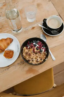 a table with a bowl of cereal and a plate of food at Basecamp Amsterdam in Amsterdam