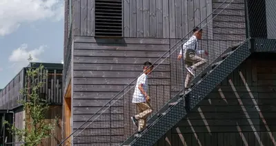 two men are on a rope ladder on a building at Basecamp Amsterdam in Amsterdam