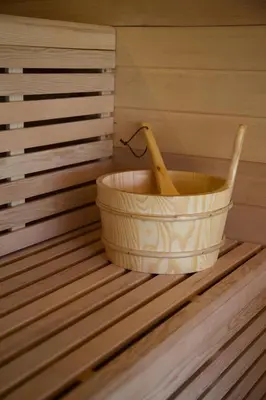 a tub with a wooden paddle in a sauna at Basecamp Amsterdam in Amsterdam