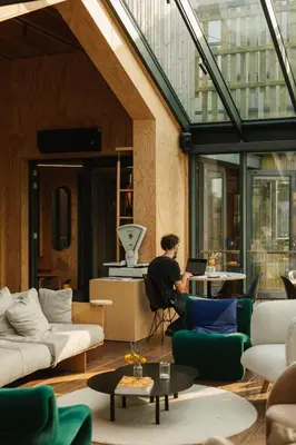 a man sitting in a chair in a living room at Basecamp Amsterdam in Amsterdam