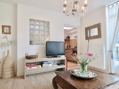 a living room with a tv and a table at Casa duna Oceans terrace and Ocean spray garden close to the beach and city centre in Zandvoort