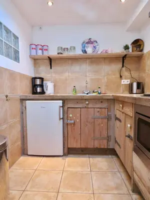 a kitchen with wooden cabinets and a white dishwasher at Casa duna Oceans terrace and Ocean spray garden close to the beach and city centre in Zandvoort