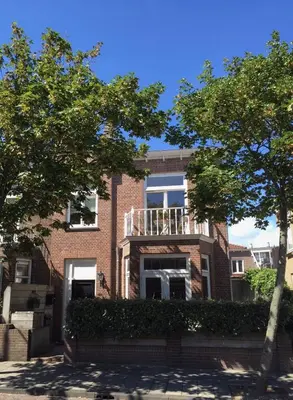 a brick building with a balcony on top of it at Casa duna Oceans terrace and Ocean spray garden close to the beach and city centre in Zandvoort