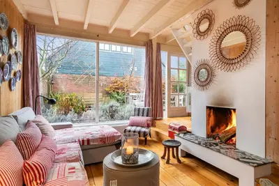 a living room with a couch and a fireplace at Het Zeepaartje, knus en gezellig in Noordwijkerhout