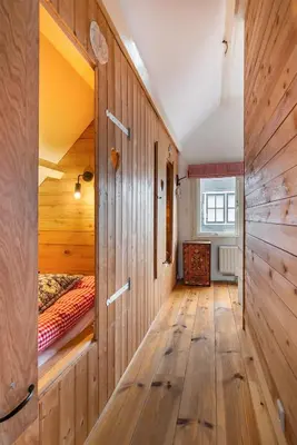 a bedroom with wooden walls and wooden flooring at Het Zeepaartje, knus en gezellig in Noordwijkerhout