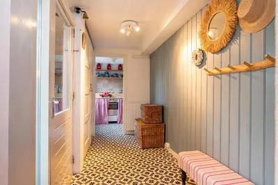 a room with a hallway with a table and a room with a kitchen at Het Zeepaartje, knus en gezellig in Noordwijkerhout
