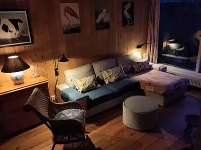 a living room with a couch and a table at Het Zeepaartje, knus en gezellig in Noordwijkerhout
