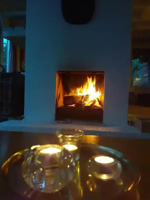a fireplace with candles and glasses on a table at Het Zeepaartje, knus en gezellig in Noordwijkerhout