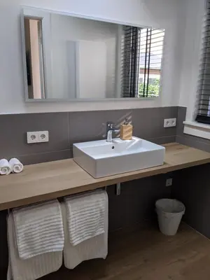 a bathroom with a sink and a mirror at Beachtime Suite in Zandvoort