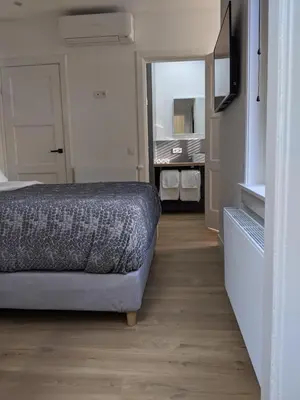 a small bedroom with a bed and a mirror at Beachtime Suite in Zandvoort