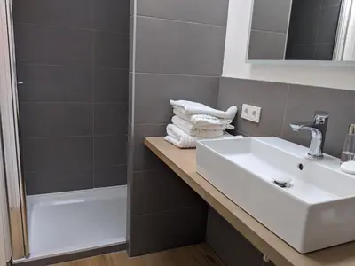 a bathroom with a sink and a shower at Beachtime Suite in Zandvoort