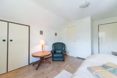 a bedroom with a bed and a chair and a table at Bed and Breakfast Hoorn in Hoorn