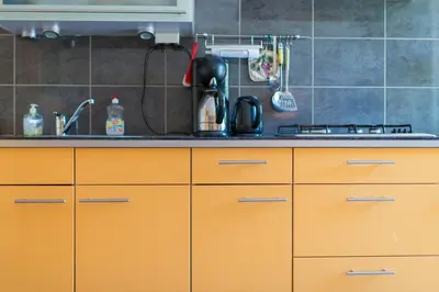 a kitchen with orange cabinets and a sink at Bed and Breakfast Hoorn in Hoorn