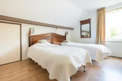 two beds with white blankets in a room with a window at Bed and Breakfast Hoorn in Hoorn