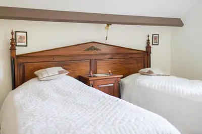 a bedroom with two white beds and a wooden headboard at Bed and Breakfast Hoorn in Hoorn