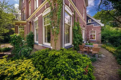 a house with a table and chairs in front of it at Boutique Appartement-Hotel Villa Juttershof in Bergen