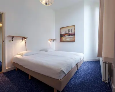 a bedroom with a bed with a painting on the wall at Boutique Appartement-Hotel Villa Juttershof in Bergen