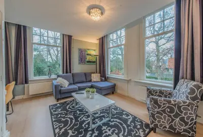 a living room with a couch and a table at Boutique Appartement-Hotel Villa Juttershof in Bergen