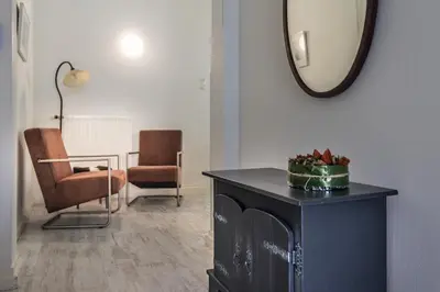 a living room with a mirror and a table and chairs at Boutique Appartement-Hotel Villa Juttershof in Bergen