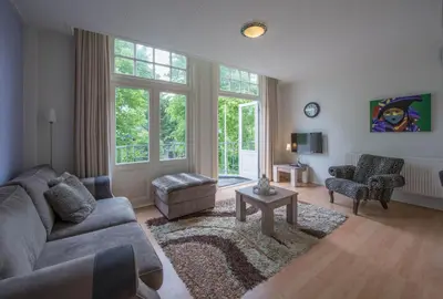 a living room with a couch and a table at Boutique Appartement-Hotel Villa Juttershof in Bergen