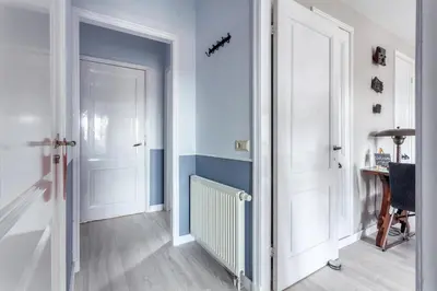a hallway with two white doors and a table at Bed and Breakfast The Rose in Haarlem