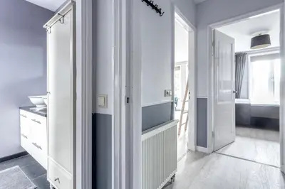 a kitchen with white cabinets and a door at Bed and Breakfast The Rose in Haarlem