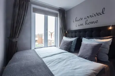 a bedroom with a large bed with a window at Bed and Breakfast The Rose in Haarlem