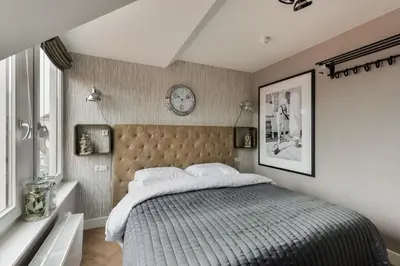a bedroom with a bed and a clock on the wall at Hotel aan de Haven in Volendam