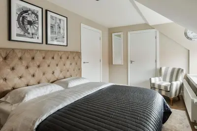 a bedroom with a large bed and two chairs at Hotel aan de Haven in Volendam