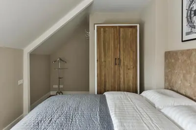 a bedroom with a bed and a wooden door at Hotel aan de Haven in Volendam