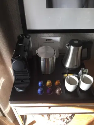 a counter with a coffee maker and cups on it at Hotel aan de Haven in Volendam