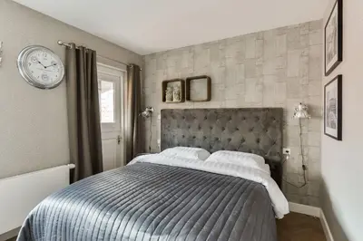 a bedroom with a bed and a clock on the wall at Hotel aan de Haven in Volendam