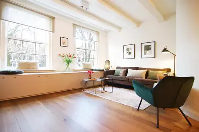 a living room with a couch and a window at Sonnenberg Canal View in Amsterdam