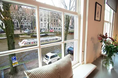 a room with a window with a view of a canal at Sonnenberg Canal View in Amsterdam
