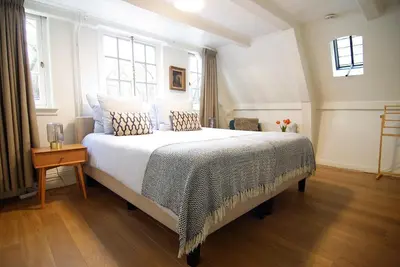 a bedroom with a large bed with white sheets and pillows at Sonnenberg Canal View in Amsterdam