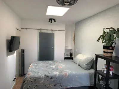 a bedroom with a bed and a television in it at Sunny Place in Zandvoort