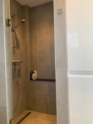 a shower with a glass door in a bathroom at Sunny Place in Zandvoort