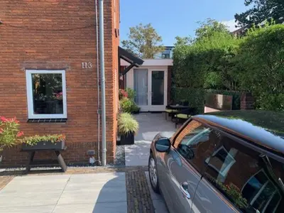 a car parked in front of a brick house at Sunny Place in Zandvoort