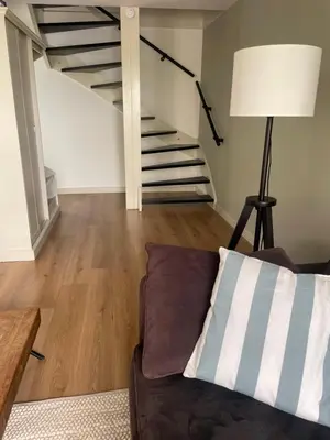 a living room with a couch and stairs at Aan de Wiericke in Driebruggen