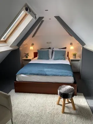 a bedroom with a large bed with blue pillows at Aan de Wiericke in Driebruggen