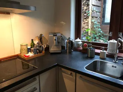 a kitchen counter with a sink and a window at Ecolodge de Parel Schoorl in Schoorl