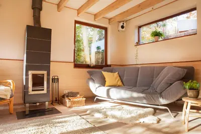 a living room with a couch and a fireplace at Ecolodge de Parel Schoorl in Schoorl