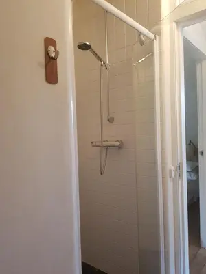 a shower in a bathroom with a glass door at Ecolodge de Parel Schoorl in Schoorl