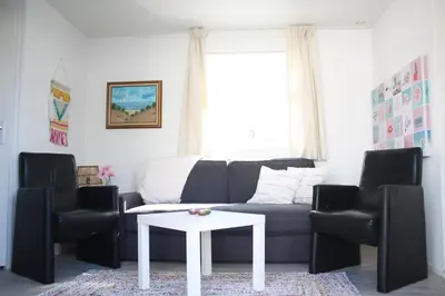 a living room with a couch and two chairs and a table at Chalet Charlee in IJmuiden