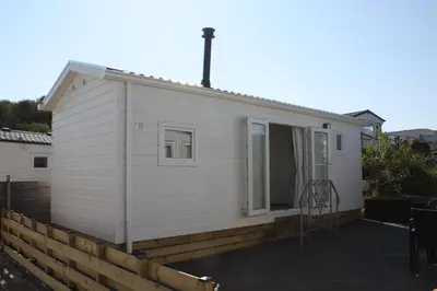 a tiny house with a porch and a patio at Chalet Charlee in IJmuiden