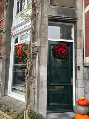 a green door with wreaths on a building at Lovely small apartment in 'De Pijp' in Amsterdam