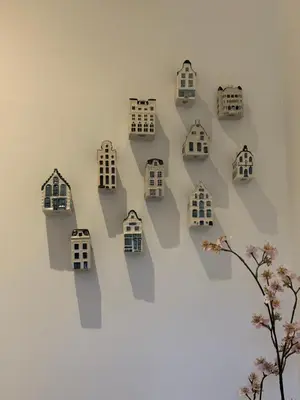 a wall with houses on a white wall at Lovely small apartment in 'De Pijp' in Amsterdam