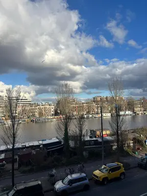 a view of a river and a city with cars at Lovely small apartment in 'De Pijp' in Amsterdam